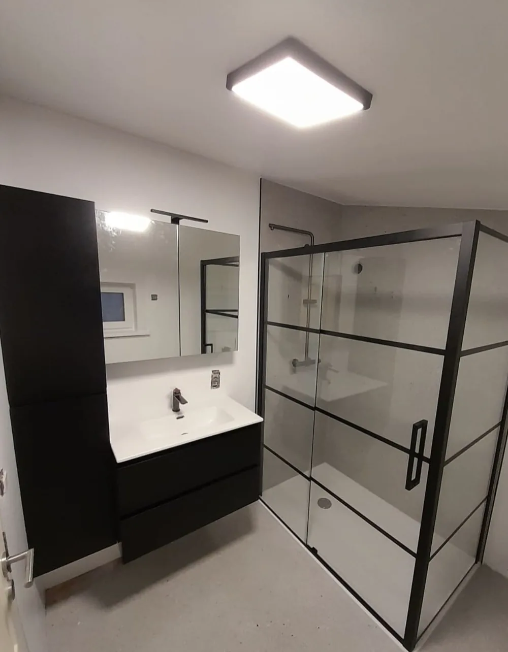 Badkamer met zwarte douchewand en wastafelmeubel